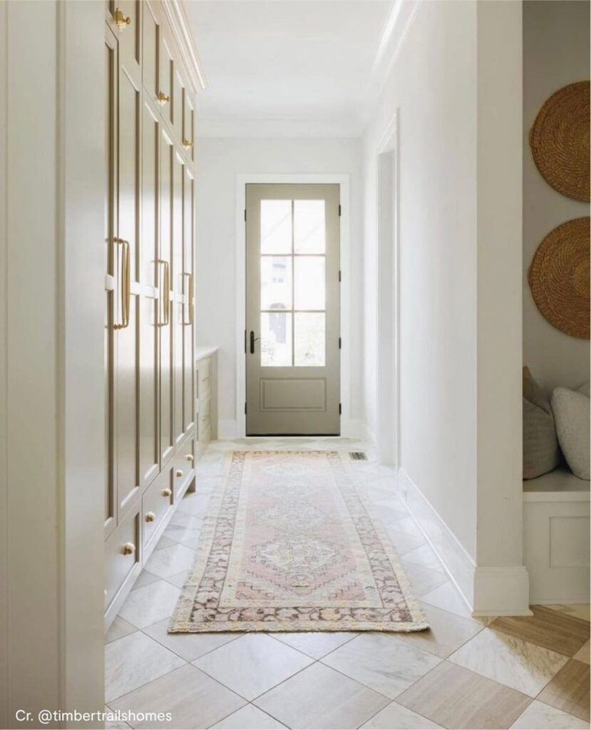 โถงทางเข้าบ้านสีสไตล์โมเดิร์นคลาสสิก ผนังทาด้วยเฉดสีขาวครีม Classic Gray OC-23 จับคู่กับประตูและตู้บิวท์อินสีเบจ Waynesboro Taupe 1544 จาก Benjamin Moore ให้บรรยากาศสวยอบอุ่น